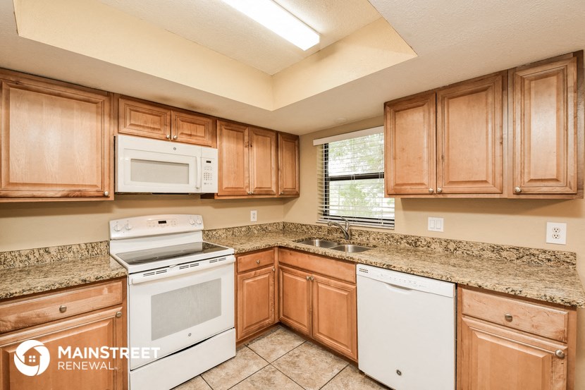 a kitchen with wooden cabinets and white appliances and granite counter tops