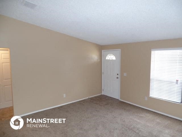 a room with a white door and a window and a carpet