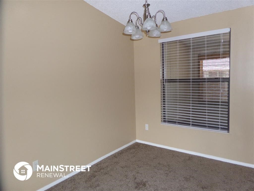 an empty room with a window and a lamp