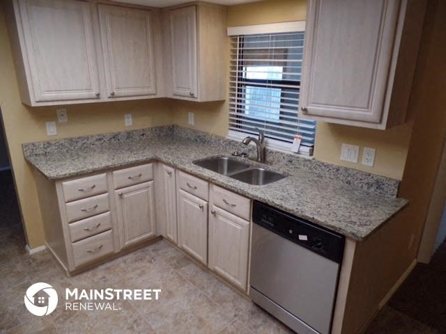 a kitchen with white cabinets and a sink