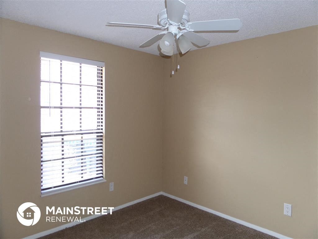a bedroom with a ceiling fan and a window