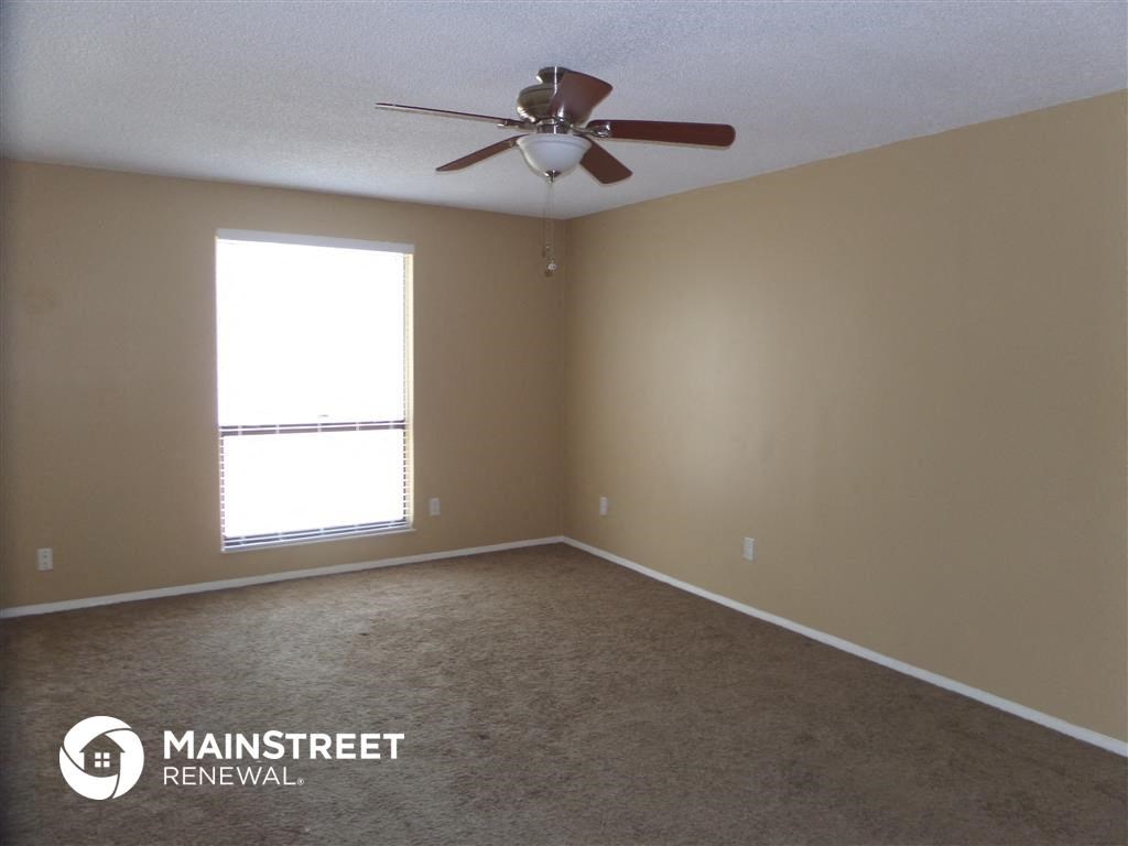 a bedroom with a ceiling fan and a window