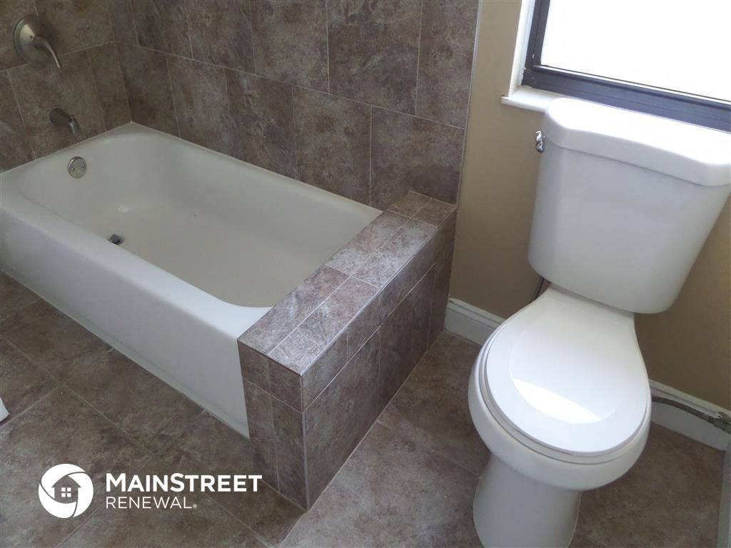 a bathroom with a toilet and a bath tub