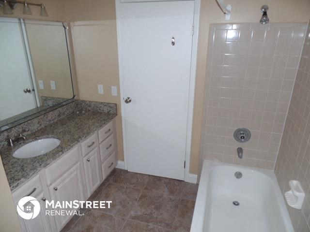 a bathroom with a bath tub and a sink and a mirror