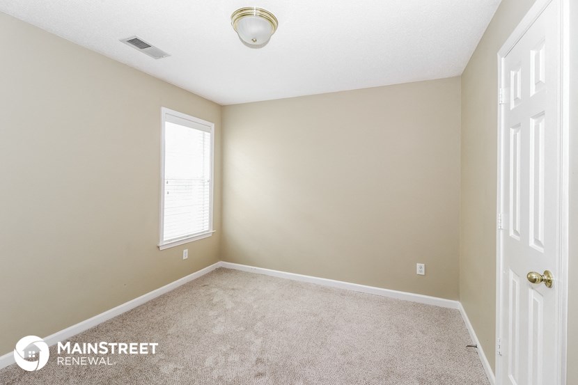 the master bedroom has a carpeted floor and a large window