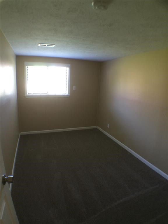 an empty room with a window and a door