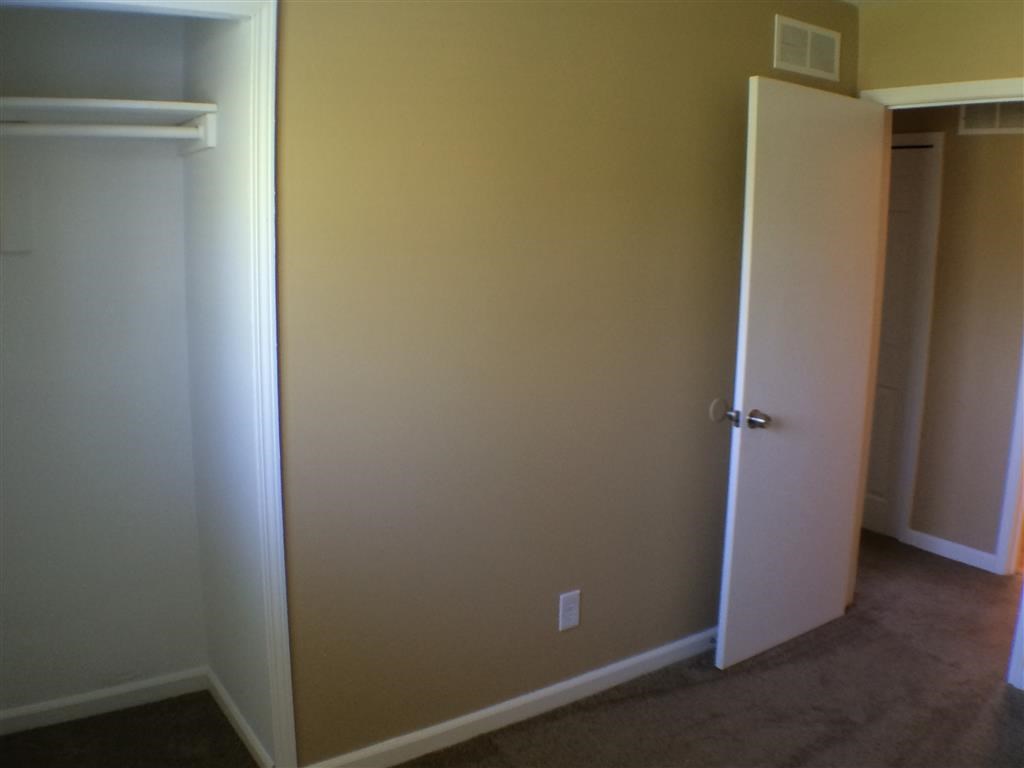 an empty room with a closet and an open door