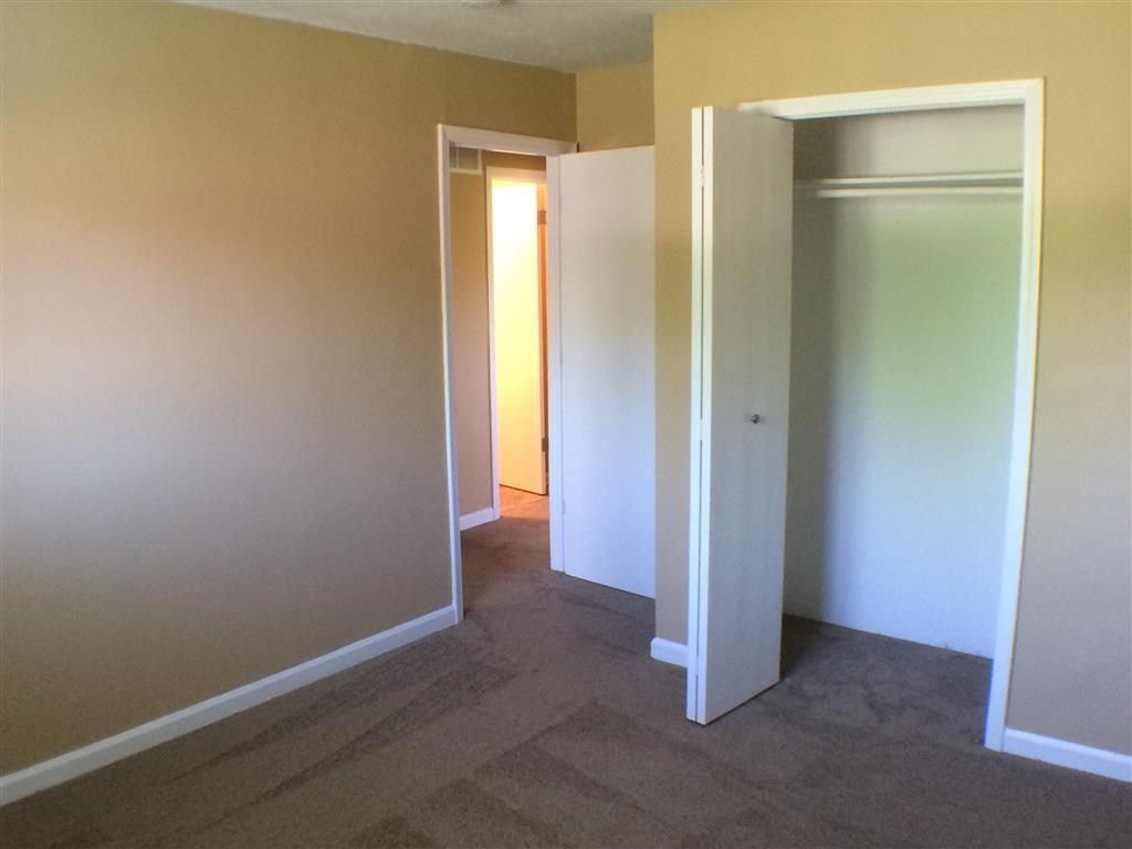 an empty room with a hallway with open doors