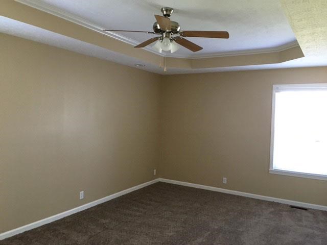 an empty living room with a ceiling fan