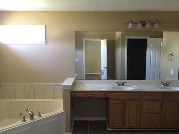 a bathroom with a sink and a tub and a mirror