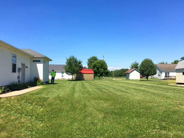 a man standing in a yard in front of a house