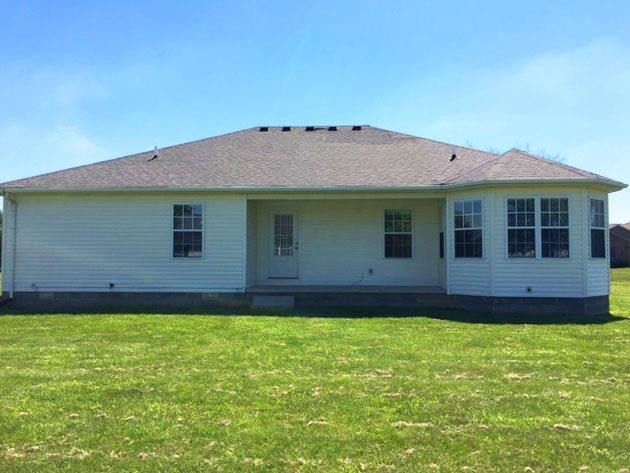 a white house sitting in a field of grass