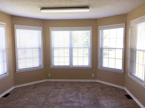 a large empty room with three windows in it