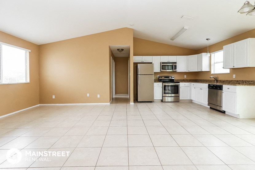 a large kitchen with white cabinets and stainless steel appliances