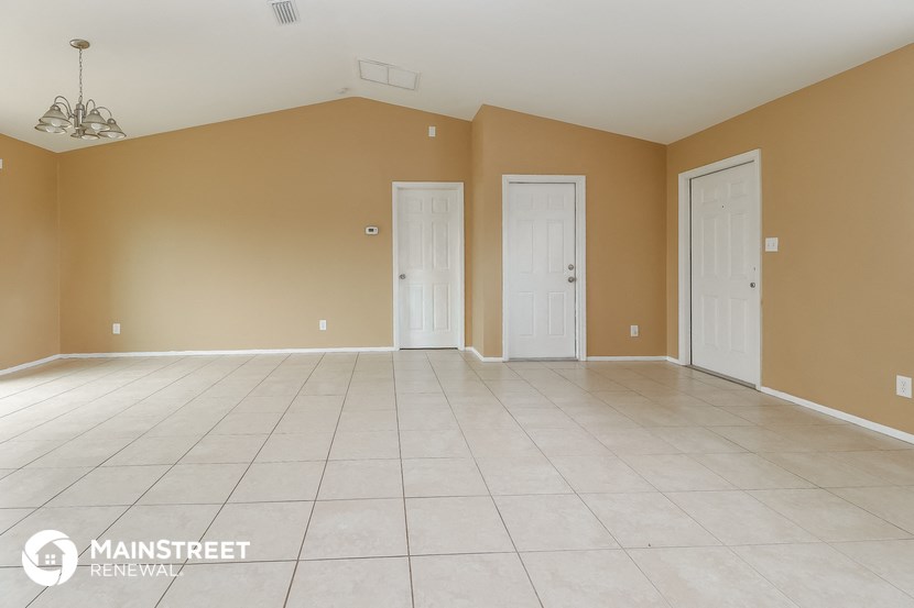 an empty room with two doors and a tile floor