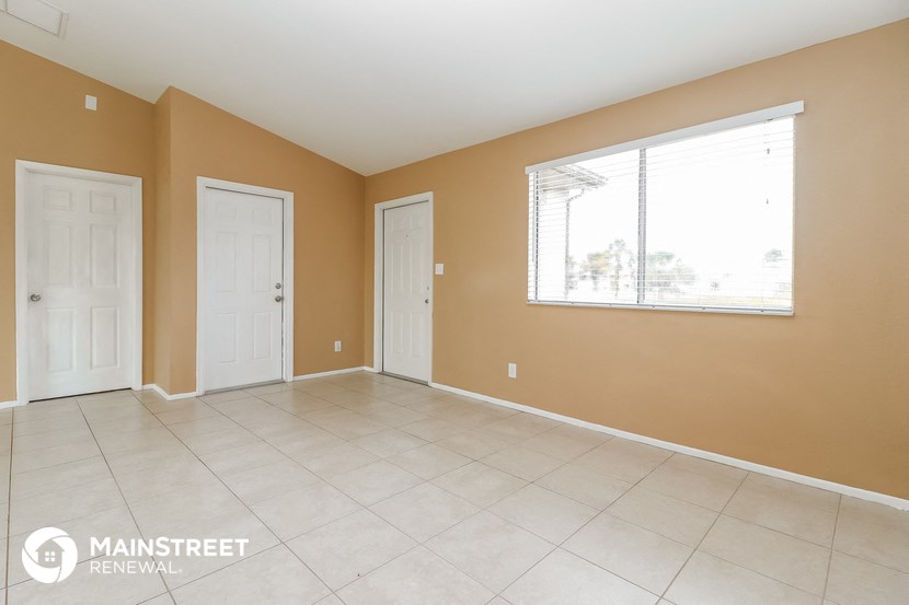 a large living room with two doors and a window