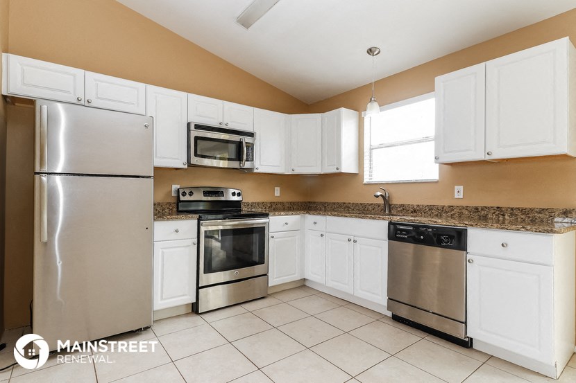a kitchen with white cabinets and stainless steel appliances