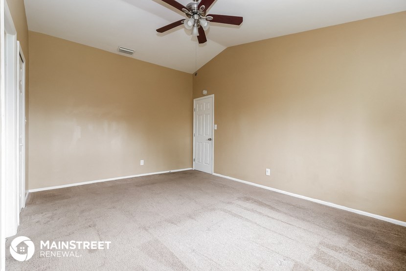 the living room of an empty house with a ceiling fan