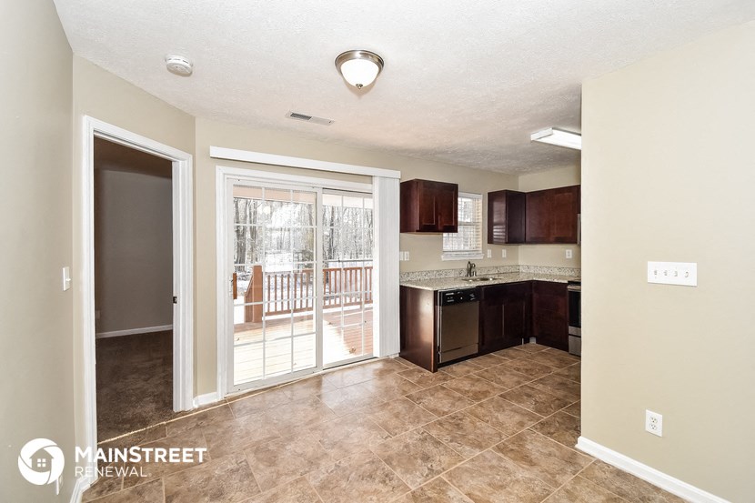 a kitchen with a sliding glass door leading to a balcony