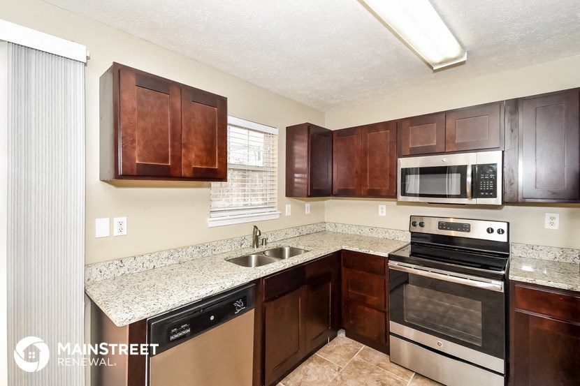 a kitchen with wood cabinets and granite counter tops and stainless steel appliances