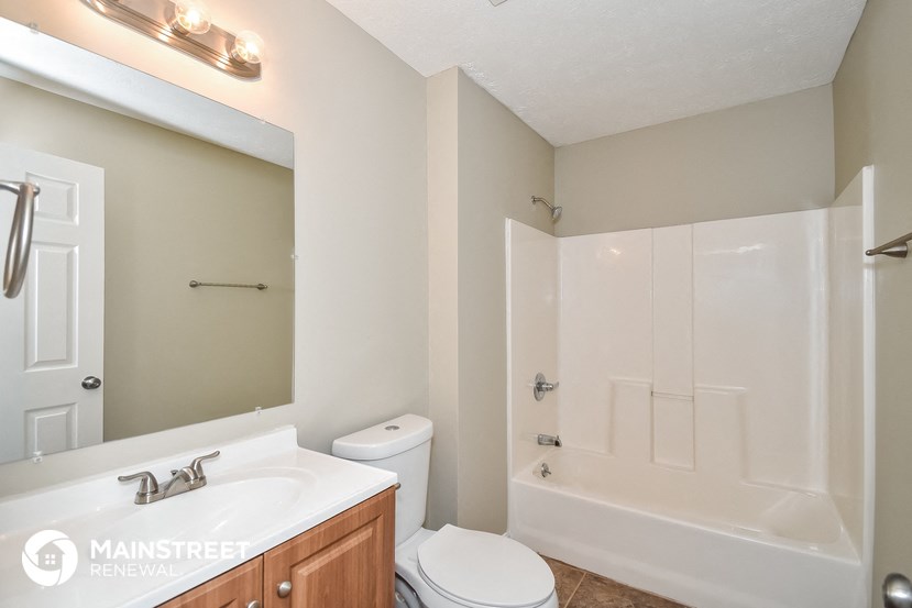 a bathroom with a white shower and a sink and a toilet