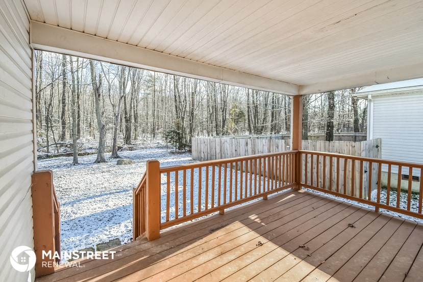the screened porch has a view of the snow covered woods