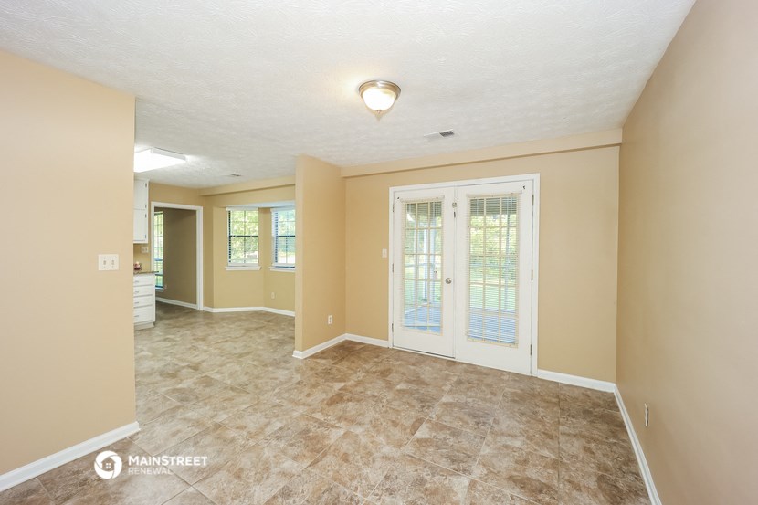 the living room and dining room of an empty house