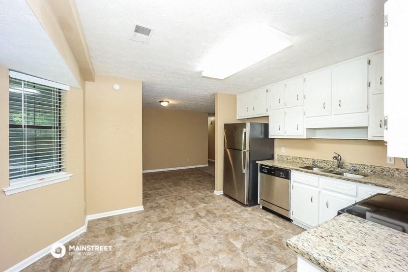 a kitchen with white cabinets and a stainless steel refrigerator