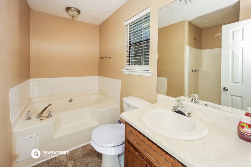 a bathroom with a tub and a sink and a toilet
