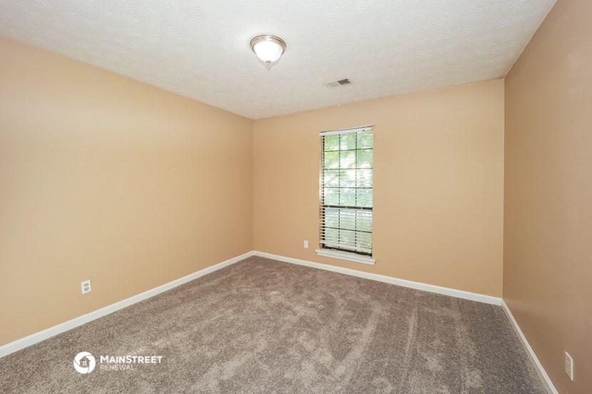 an empty living room with carpet and a window