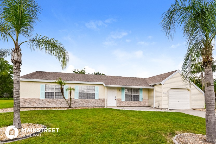 a white house with palm trees in front of it