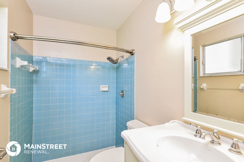 a bathroom with a shower and a sink and a toilet