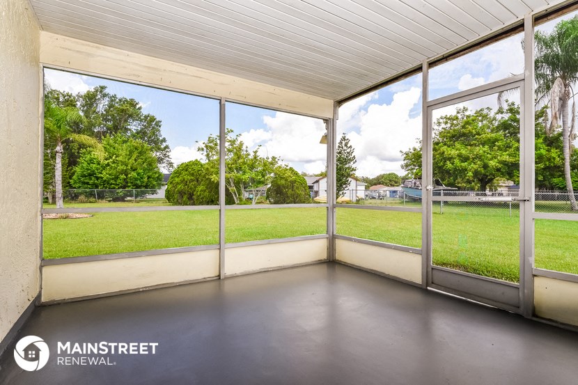 a screened in porch with a view of the yard and the grass