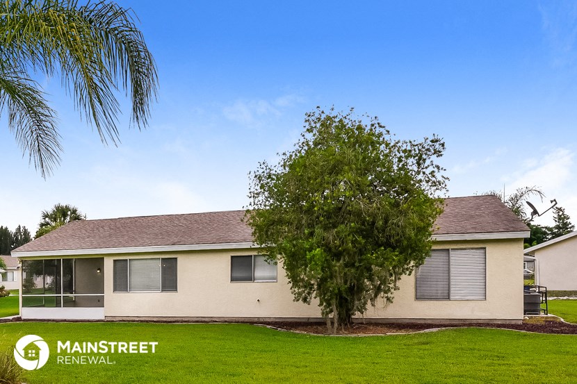 a small white house with a tree in front of it