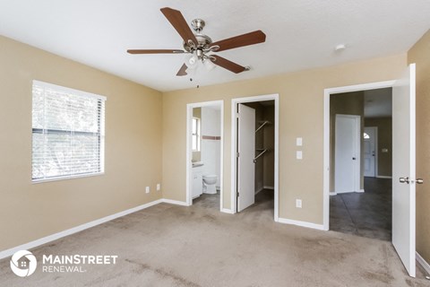 a living room with carpet and a ceiling fan