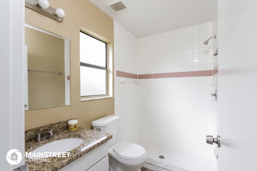 a bathroom with a toilet sink and shower and a mirror