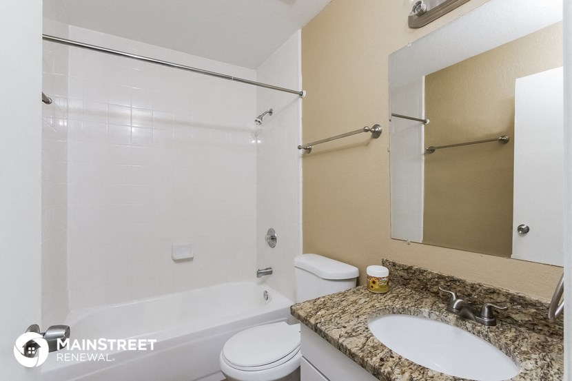 a bathroom with a shower toilet and sink and a mirror