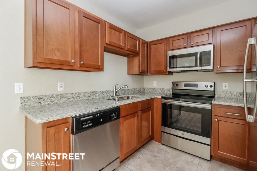 a kitchen with wooden cabinets and stainless steel appliances and granite counter tops