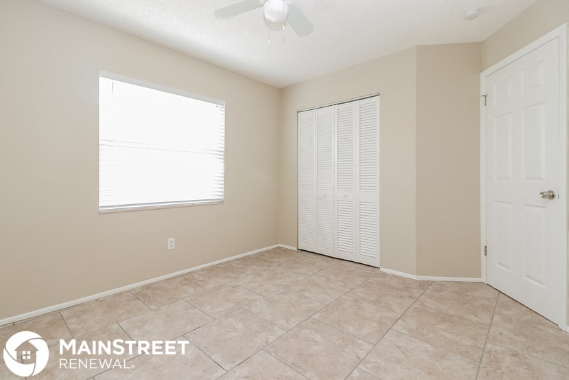 a living room with a tile floor and a large window