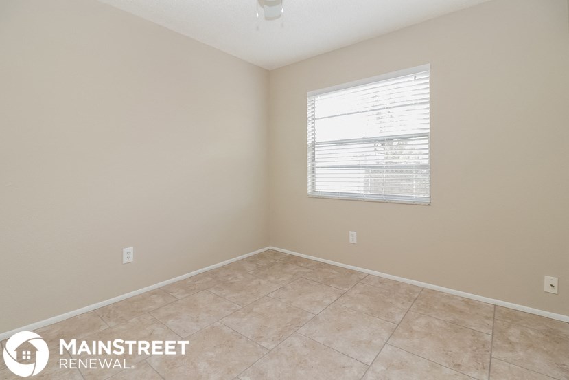 a small room with a window and a tiled floor