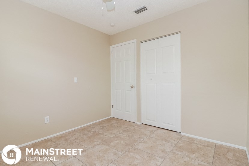a bedroom with two closets and a tiled floor