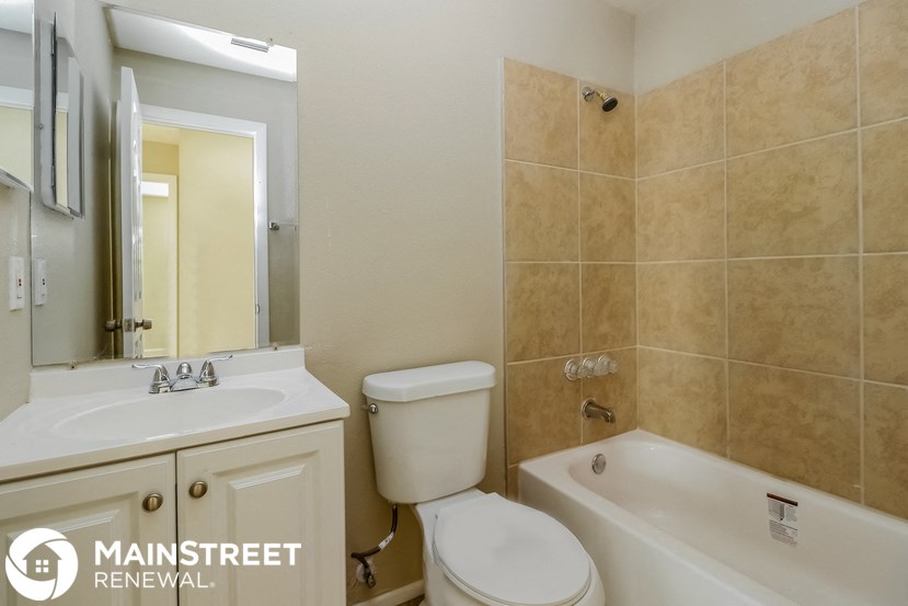 a bathroom with a toilet sink and tub and a mirror