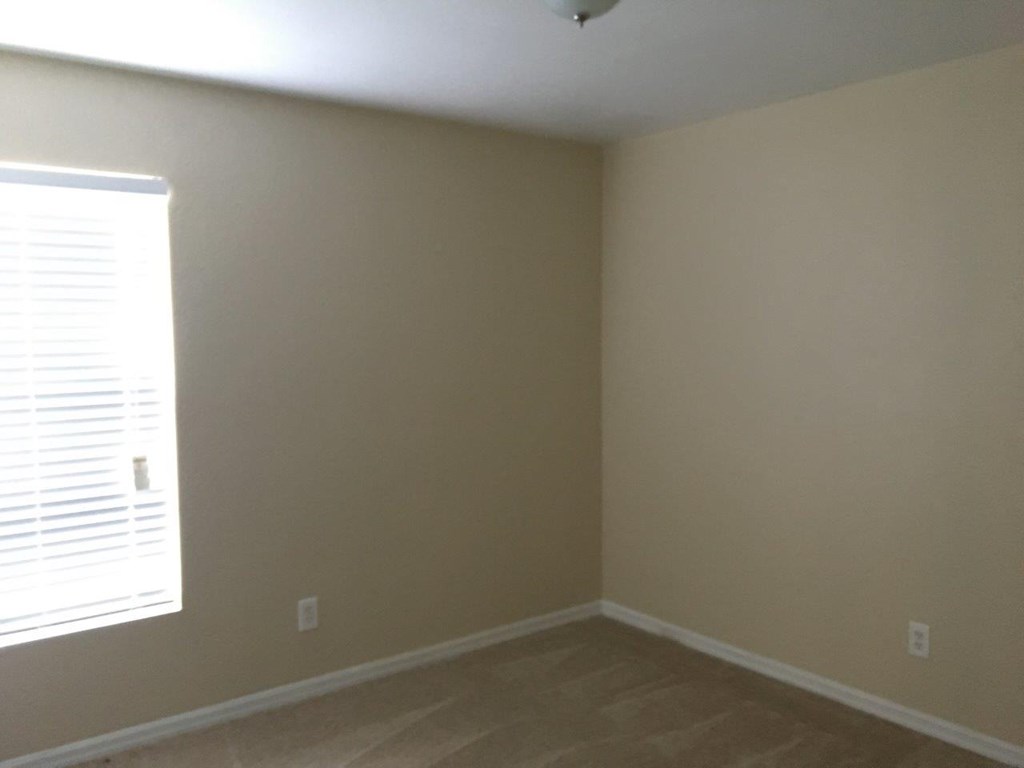 a empty room with a window and wooden floors