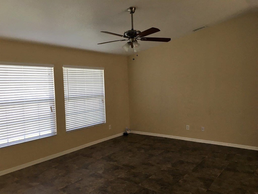a living room with a ceiling fan and a window