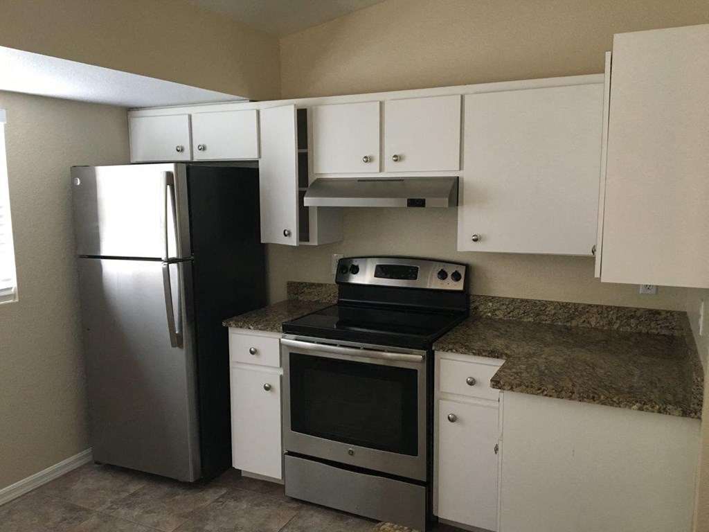 a kitchen with stainless steel appliances and white cabinets