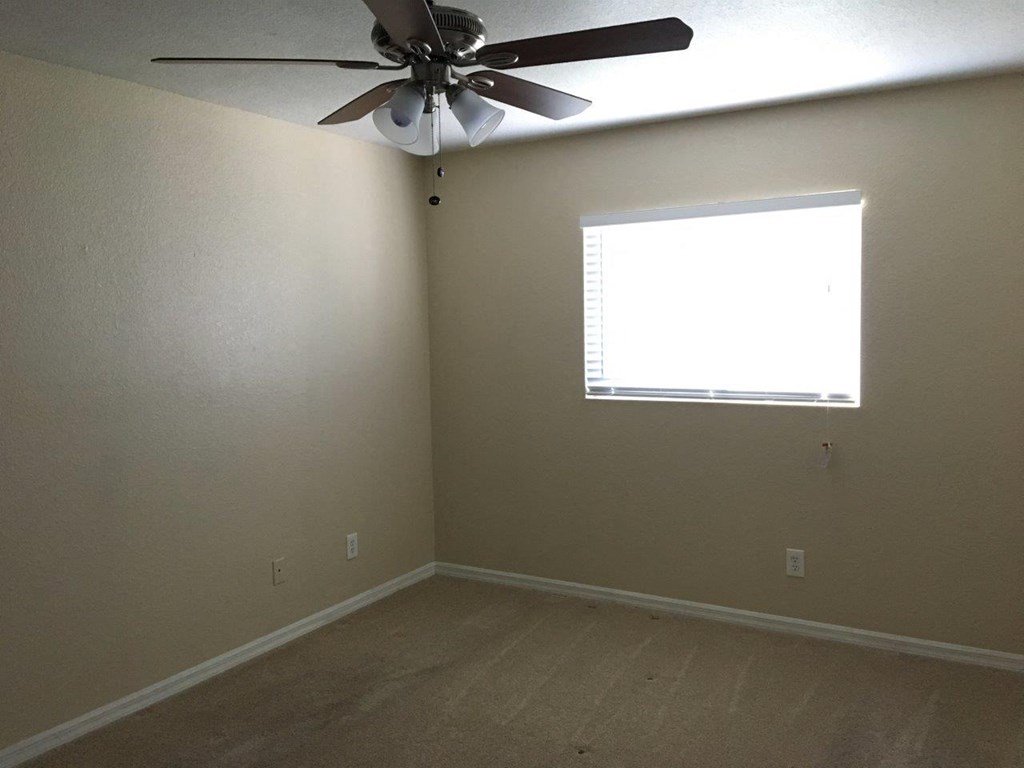 a room with a ceiling fan and a window