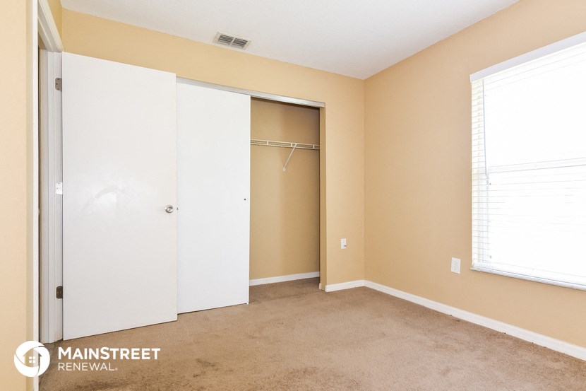a bedroom with a closet and a window