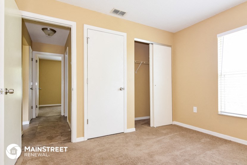 a master bedroom with three closets and a carpeted floor