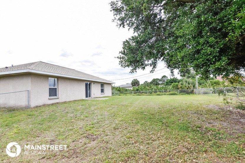 a small house with a yard and a tree