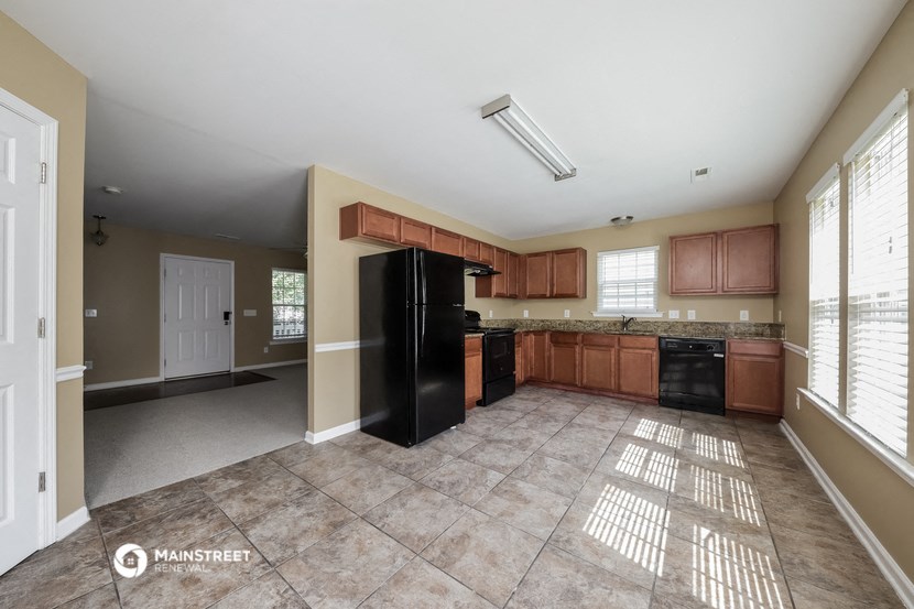 a large kitchen with black appliances and wooden cabinets